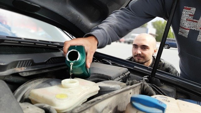 pouring oil into car